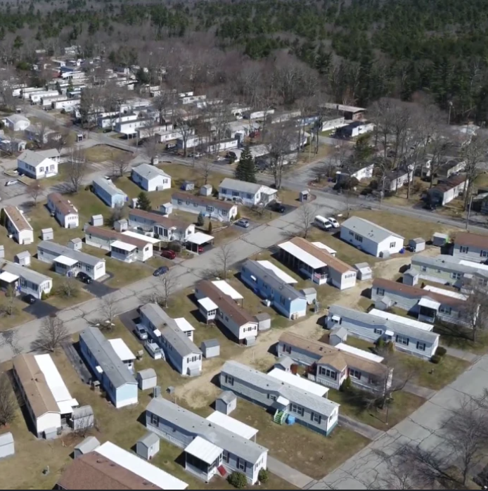Aerial view of manufactured homes and tree-lined streets in a residential community